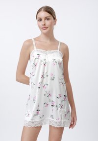 Camisón de satén blanco con estampado floral en rosa, con encaje en el escote y el bajo, tirantes finos ajustables, textura suave, diseño hasta la rodilla.