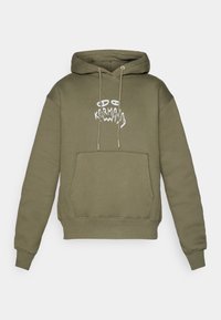 Sweat à capuche vert olive avec poche avant, cordons de serrage et graphique de visage abstrait blanc avec le texte "Karma" sur la poitrine.