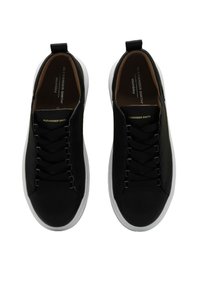 Sneaker nere con finitura liscia, dotate di una suola in gomma bianca, lacci piatti e un'etichetta sul tallone. Logo del marchio in oro sulla linguetta.