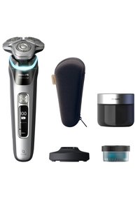 Philips Series 9000 elektrische scheerapparaat in zilver en zwart, met een ontwerp met drie koppen, een oplaadstation, een reiskoffer en verzorgingscrème.