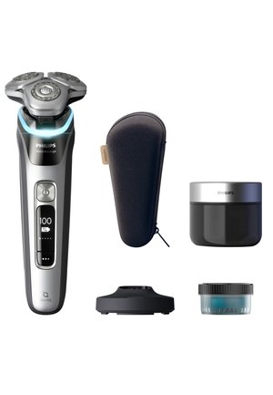 Philips Series 9000 electric shaver in silver and black, featuring a three-head design, a charging base, a travel case, and grooming cream.