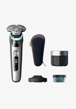 Philips Series 9000 electric shaver in silver and black, featuring a three-head design, a charging base, a travel case, and grooming cream.