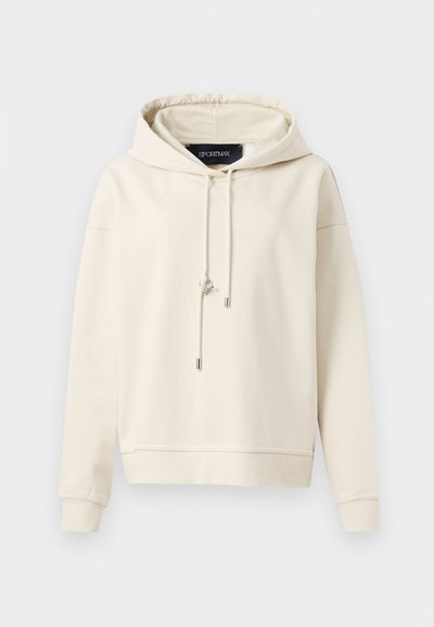 Kremna kapuca iz mehke tkanine, ki ima zavezo na vrvico, rebraste manšete in sproščen kroj. Brez grafik ali vzorcev.