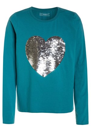 Chemise à manches longues couleur sarcelle avec un grand cœur en sequins argentés brillants au centre.