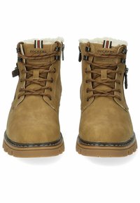 Bottes en cuir marron à lacets avec une tige synthétique, doublure en fourrure et accents métalliques. Elles présentent une semelle robuste et une étiquette de marque sur la languette.