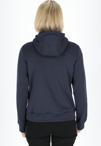 Felpa blu navy con cappuccio, maniche lunghe e orlo aderente. Realizzata in un materiale morbido e liscio, senza motivi o dettagli visibili.