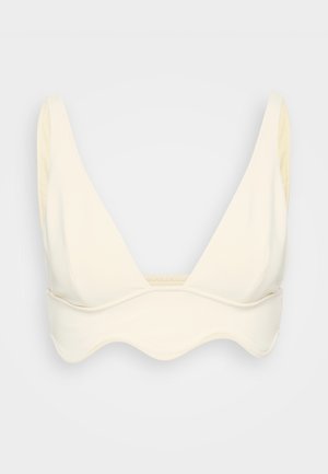 Bralette couleur crème, à texture douce, de forme triangulaire, avec des bretelles larges et un détail d'ourlet festonné.