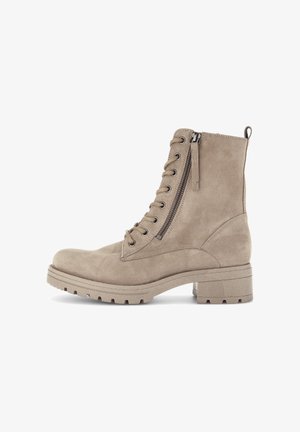 Beige suede ankle boots with a round toe, lace-up front, side zipper, and a thick, textured sole.