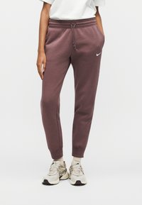 Μπορντό παντελόνια τζόγκερ από απαλό ύφασμα με στενή σχεδίαση, ελαστική μέση με κορδόνι και μικρό λευκό λογότυπο Nike στο αριστερό μηρό.