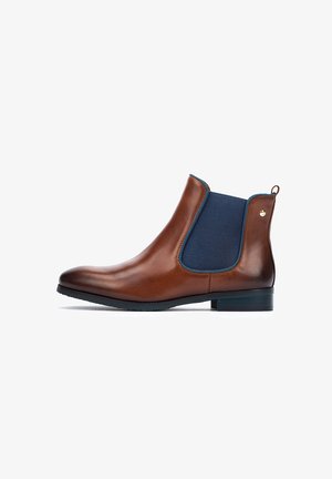 Brown leather ankle boots with navy elastic panels, rounded toe, low heel, and gold logo detail on the back. Smooth texture.
