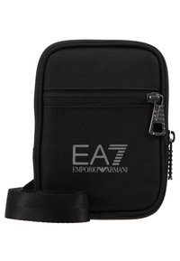 Borsa a tracolla nera in tessuto con tasca frontale con zip, con il logo EA7 Emporio Armani in bianco. Include una tracolla regolabile.
