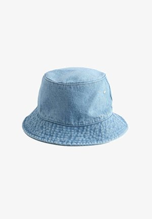 Hele sinine teksariidest kaloss, millel on õmmeldud serv ja õhuavadega silmad, esitatud ühevärvilise valge tausta taustal.