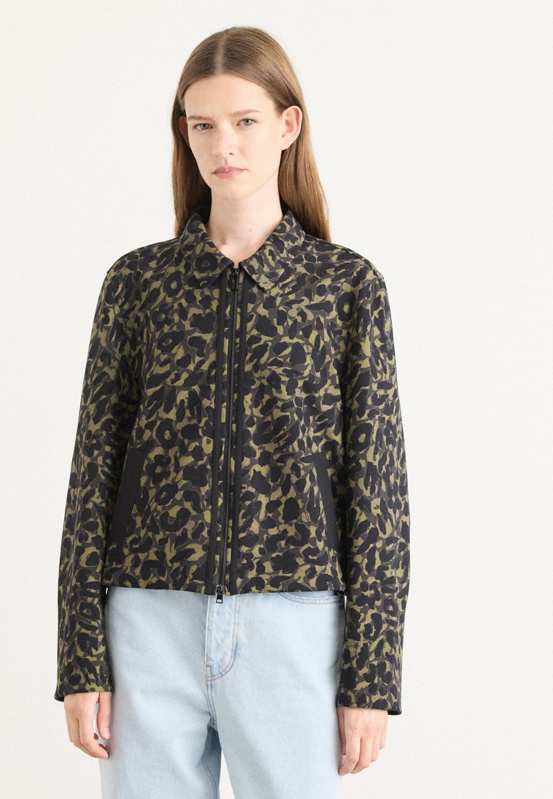 Leopardprint jack in zwart en olijfgroen, met een rits aan de voorkant, een kraag en twee zijvakken. De stof heeft een gladde textuur.