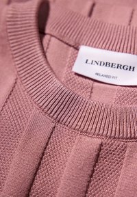 Różowy sweter z dzianiny z prążkowanym okrągłym dekoltem, teksturowanymi wzorami oraz metką z napisem "LINDBERGH RELAXED FIT".