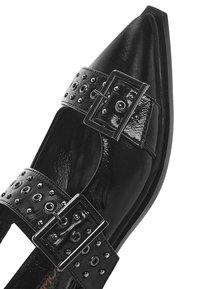 Chaussure en cuir verni noir à bout pointu, dotée de deux larges sangles avec boucles argentées et clous décoratifs le long des bords.