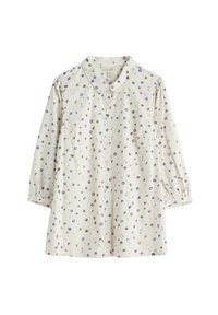 Kragskjorta i cremefärgad tyg med lila, gröna och blå prickar. Har långa puffärmar och en knäppning framtill med en bröstficka.