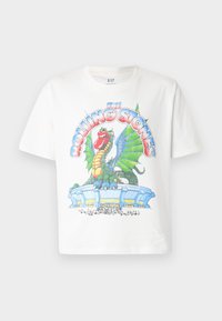 White cotton T-shirt featuring a colorful graphic print of a dragon and stadium, with "The Rolling Stones" text in bold, stylized lettering.