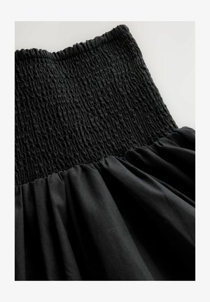 Must kleit voltseeritud ülakehaga, millel on vöökohtadest allapoole kogutud kangas. Sile tekstuur ja voolav siluett.