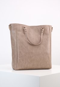 Bolso tote de imitación de cuero beige con dos asas para el hombro, forma rectangular, textura suave y diseño minimalista. Acentos en tono dorado.