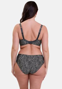 Soutien-gorge noir et bas de bikini assortis avec un motif floral blanc. Bretelles réglables, fermeture à crochets et dentelle sur la taille.