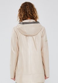 Beige leather jacket with a hood, featuring a smooth texture and subtle sheen. Includes a contrasting striped detail at the collar.