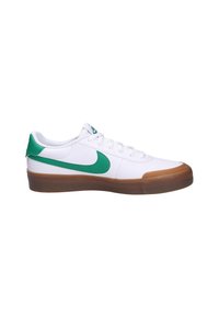 Witte sneakers met groene accenten, voorzien van een rubberen zool, vetersluiting en een opvallend Nike swoosh-logo op de zijkant.