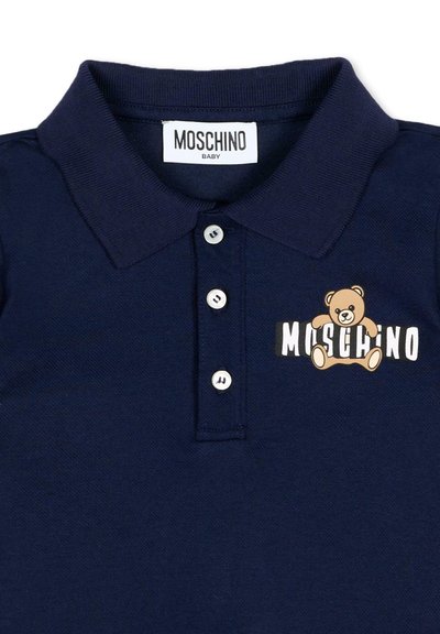 Polo per bambini blu navy con tre bottoni bianchi, etichetta Moschino e logo dell'orsacchiotto che tiene il nome del marchio sul petto.