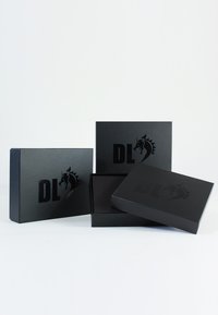 Black cardboard boxes with a matte finish, featuring embossed logo. Two boxes are open, revealing smooth interiors.