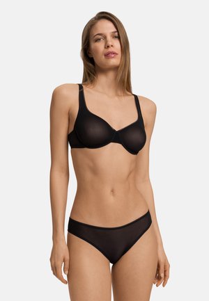 Musta alusvaatesetti, joka sisältää läpinäkyvän liivit, joissa on vaijerituet ja säädettävät olkaimet, sekä yhteensopivat bikinityyliset alushousut.
