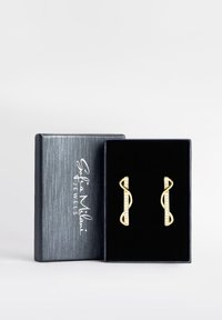 Guldörhängen i ett oändlighetsdesign med en rad av klara kristaller, presenterade i en svart sammetlåda med en silverlogotyp på locket.