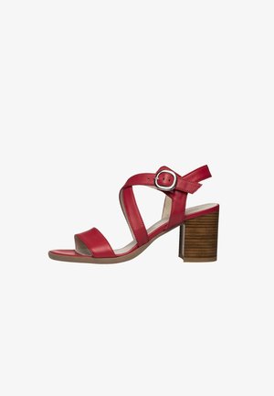 Sandalia de piel roja de dedo abierta con correa ajustable y tacón de bloque de madera apilado, mostrada en perfil lateral sobre fondo blanco.