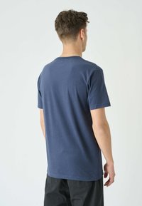 Navyblaue Baumwoll-T-Shirt mit rundem Ausschnitt und kurzen Ärmeln, das eine glatte Textur und einen geraden Schnitt am Saum zeigt.