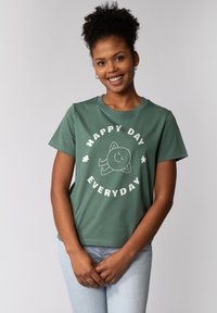 T-shirt en coton vert avec un col rond, des manches courtes et un design graphique avec le texte "HAPPY DAY EVERYDAY" et un personnage souriant.