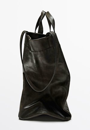 Black leather tote bag with a textured finish, featuring dual handles and a spacious opening. Soft, unstructured shape with a flat base.