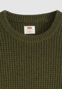 Olijfgroen geribbelde gebreide trui met een ronde halslijn en een Levi's label. Ontworpen voor een standaard pasvorm, met een gestructureerde stof.