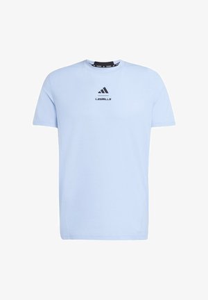 Light blue short-sleeve athletic t-shirt with black Adidas logo and "LES MILLS" text centered on the chest.