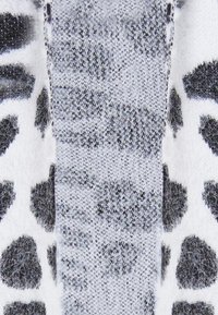 Strikstof med et monokromt leopardmønster og en blød tekstur. De kontrasterende sorte og hvide farver skaber en dristig visuel appel.