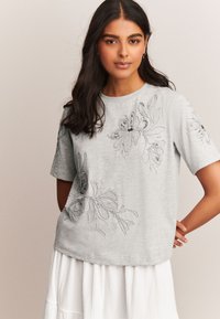 Grijze t-shirt met korte mouwen met bloemborduurwerk in zilveren tinten, met gekleurde accenten en een comfortabele pasvorm. Zacht katoenen materiaal.