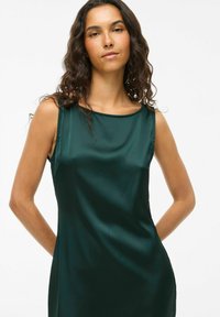 Satinová zelená šaty bez rukávov s výstrihom do oblúka, hladká textúra a priliehavý strih, s jednoduchým a elegantným dizajnom.