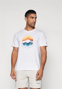 Hvid bomulds T-shirt med et farverigt bjergmotiv i orange, blå og teal. Inkluderer tekst om tilgængelighed til udendørs aktiviteter.