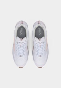 Ζευγάρι λευκά αθλητικά παπούτσια Fila με ροζ λεπτομέρειες, σχέδιο με κορδόνια και γκρι εσωτερικά πέλματα, απεικονιζόμενα από ψηλά σε ουδέτερο φόντο.