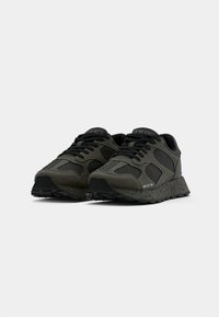 Black and dark green sneakers with mesh panels, textured rubber soles, round laces, and branding on the side. Lightweight design for comfort.