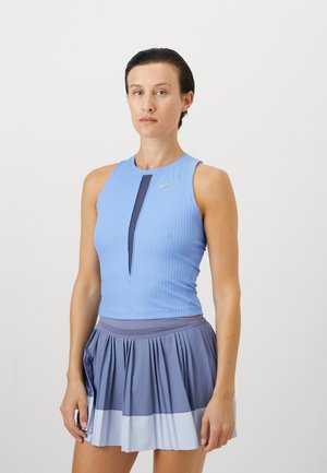 Blue ribbed tank top with a keyhole design, paired with a pleated skirt in varying shades of blue. Features a small Nike logo on the top.