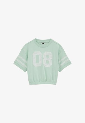 Jasnozielona krótka koszula z krótkim rękawem, z przodu biała koronkowa liczba "08" oraz dwie białe koronkowe paski na każdym rękawie.