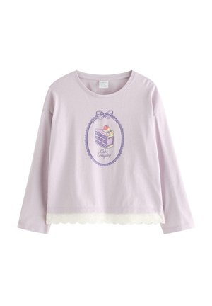 Vaaleanpunainen pitkähihaisen paidan, jossa on pitsireunus ja kehyksellinen kakunpala-kuvake, jossa lukee "Cake Everyday" etupuolella.