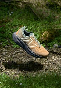 Scarpa da corsa leggera in arancione e verde. Parte superiore in mesh testurizzato con suola ammortizzata. Presenta un distintivo logo a zigzag e un tassello di apertura.