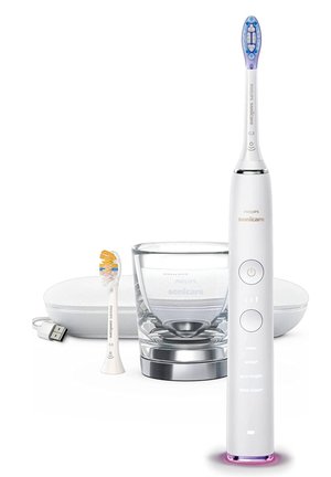 Brosse à dents électrique Philips Sonicare en blanc et argent, avec une tête de brosse bleue et jaune, accompagnée d'un verre et d'un étui de charge.