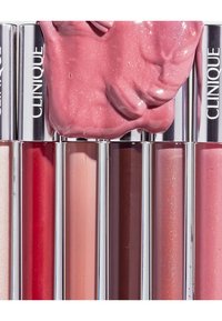 Kollektion von Clinique Lippenpflegestiften in sechs Röhren, mit Farbtönen von Hellrosa bis Dunkelrot, glänzenden Finishes und silbernen Kappen.