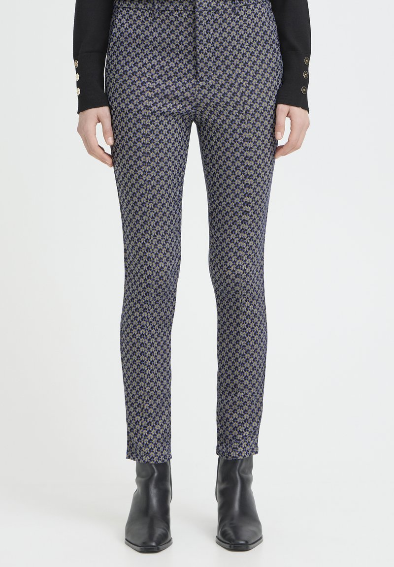 Enganliegende Leggings mit einem dunkelblauen und goldenen Hahnentrittmuster, aus glattem Stoff, mit mittlerer Bundhöhe und knöchellanger Länge.