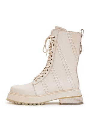 Beige veterschoenen met een robuuste zool, glad leer, verticale strepen, ronde neus en een gestructureerd hakdetail.